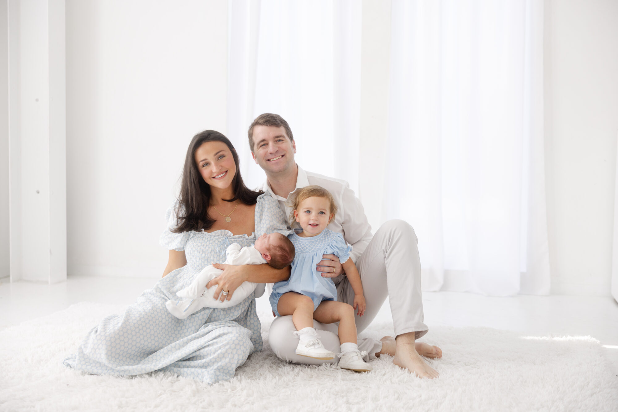 Family in all white studio for newborn session