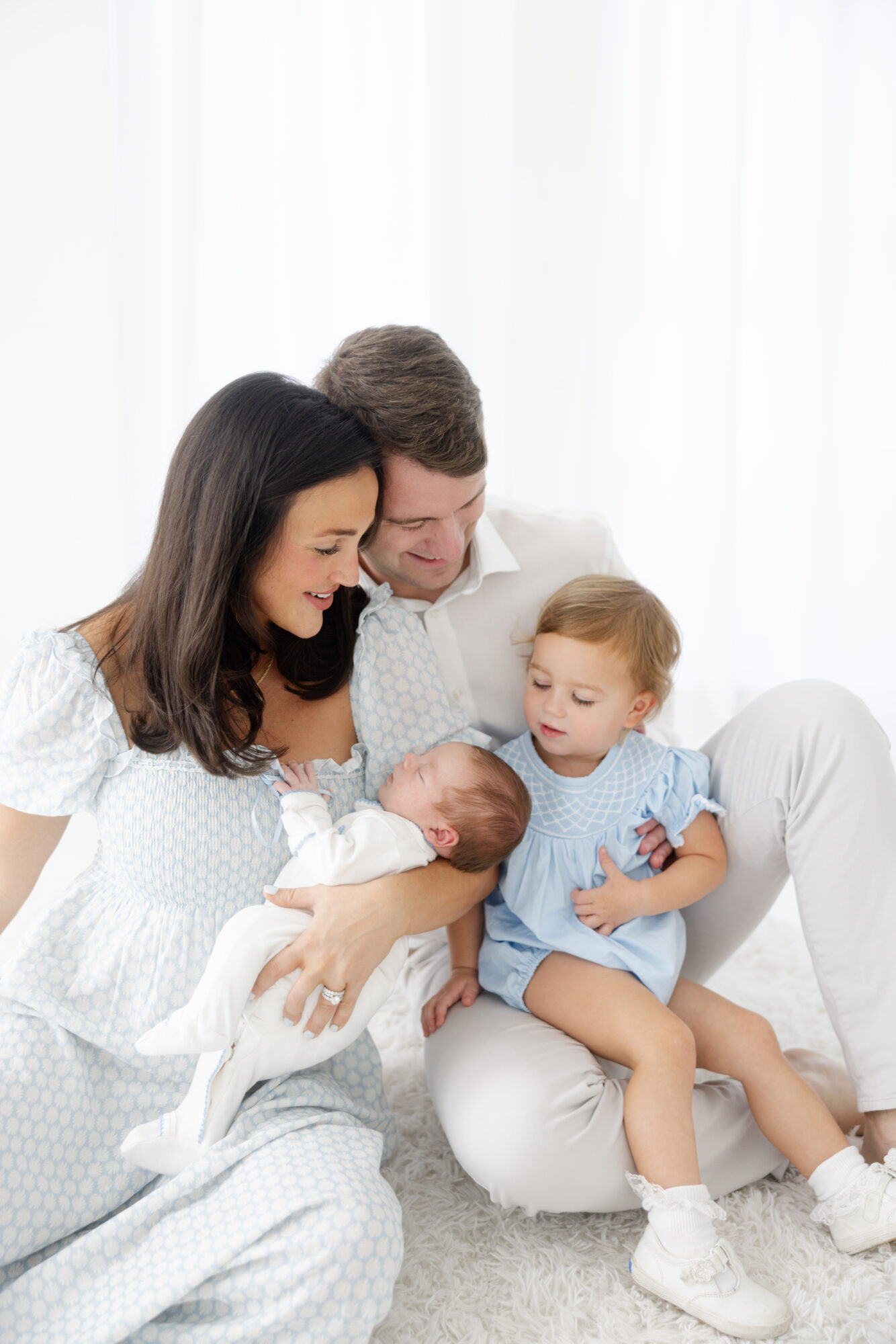 Studio session of family celebrating new baby
