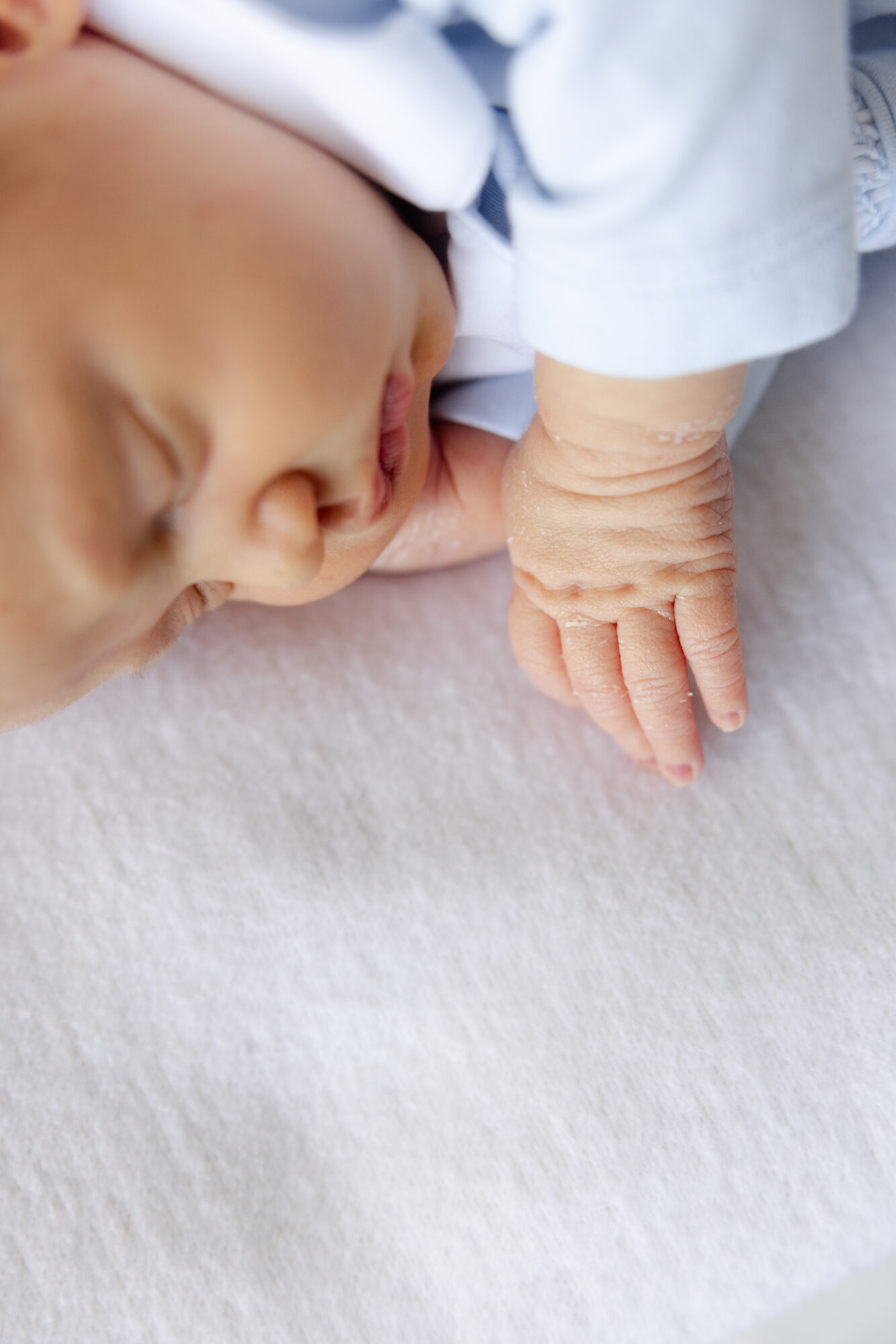 Close up of a sleeping newborn baby's face and tiny hand during a Houston lifestyle newborn session.