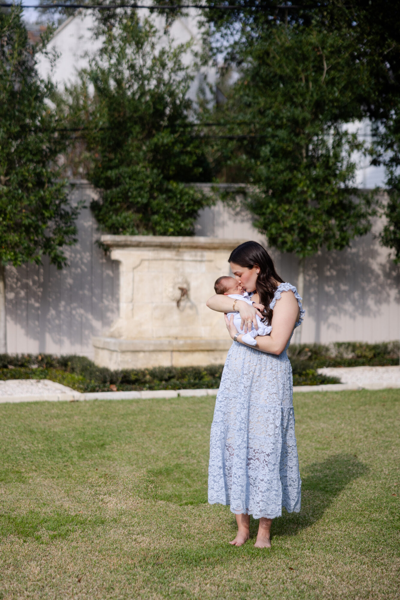 Mom holding her newborn baby outside during a Houston lifestyle newborn photography session.